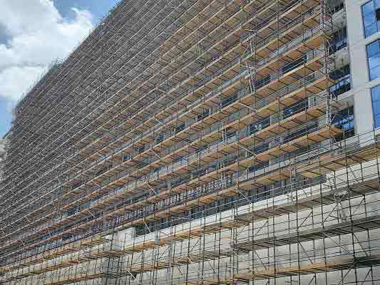 High-rise building wrapped in cuplock facade scaffolding for construction in the UAE
